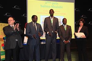 Remise des prix du Concours Léopold Sédar Senghor, de la Dictée PICADELF et de l’Art Oratoire: Prof. Albert Lourde, M.Alphonse Raphaël Ndiaye, M. Ibrahima Thiam, M.Amadou Ndiaye, la directrice de l'école Sainte Jeanne Antide en recevant le prix de la deuxième gagnante de l'oeuvre picturale Salma Shalabi.